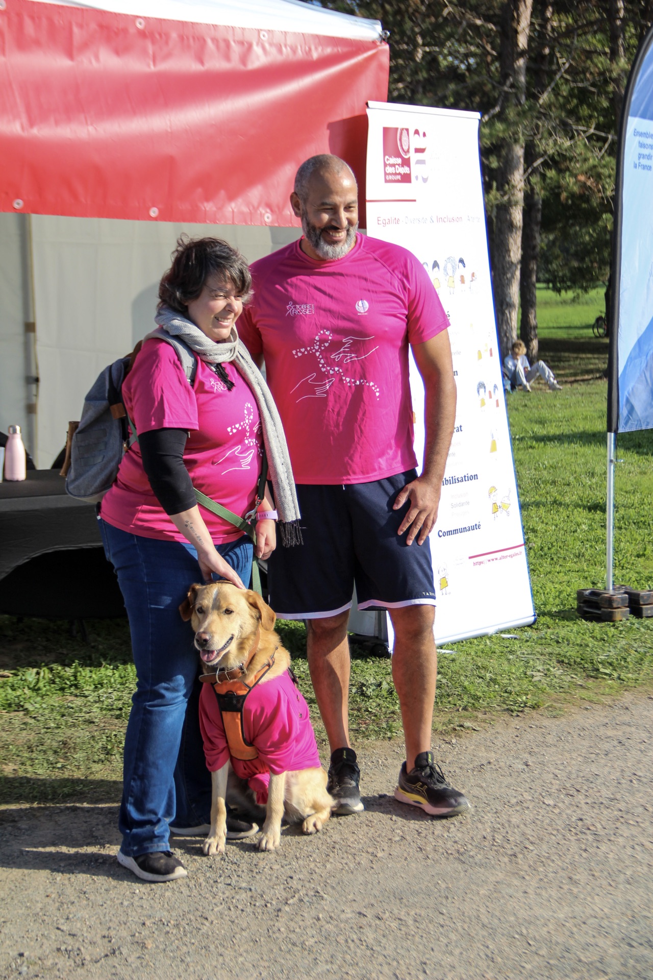 Famille et bénévoles devant un stand Octobre Rose au Lac de Maine