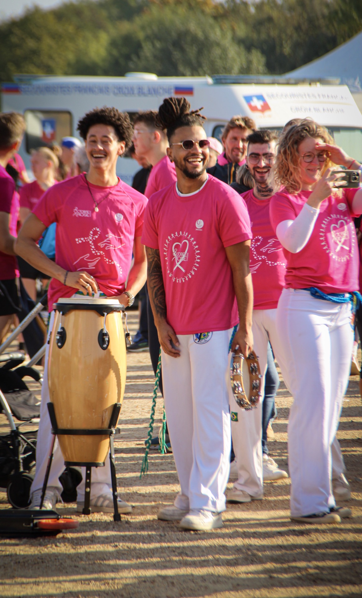 Musiciens et percussionnistes en t-shirts roses animant Octobre Rose