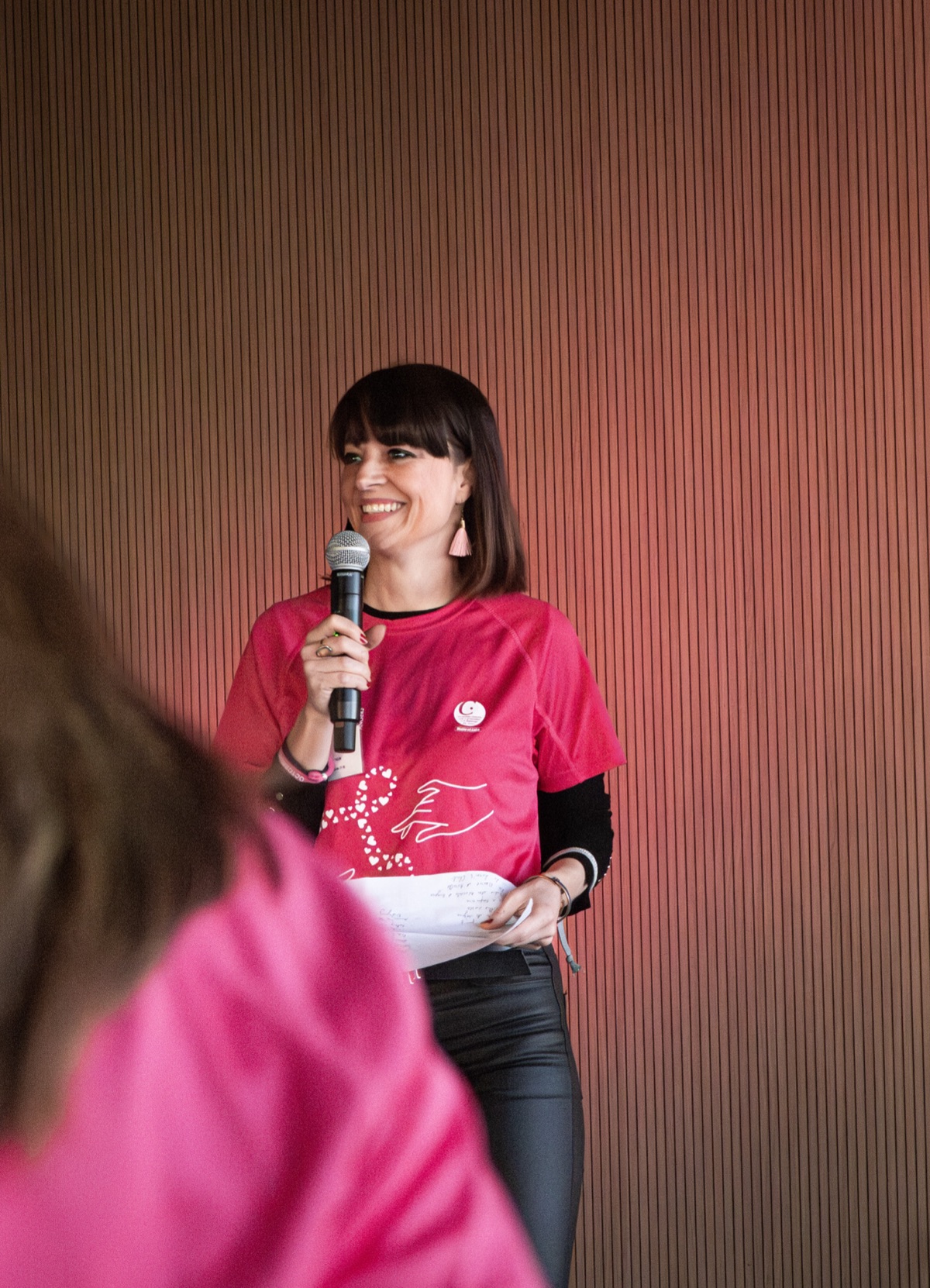 Discours d'une bénévole en t-shirt rose Octobre Rose