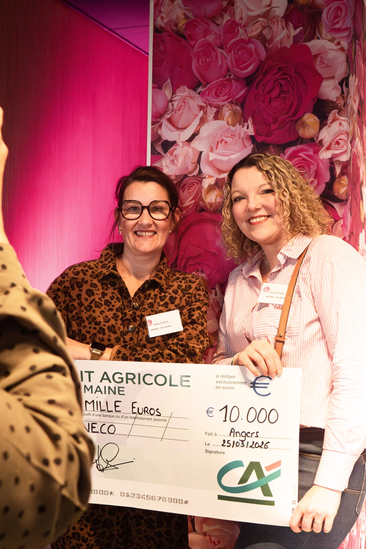 Remise de chèque devant le mur de roses lors de la soirée